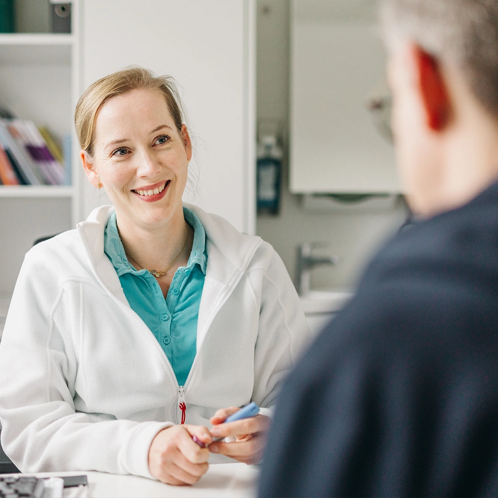 Frau Fritzsche in der Gemeinschaftspraxis Ilsede im freundlichen und beratenden Gespräch mit einem Patienten